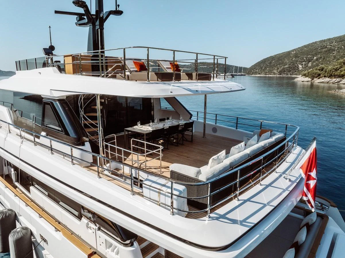 The yacht's aft deck offers a spacious and inviting area for relaxation and dining with stunning views of the surrounding water and landscape. aboard AT ONE Yacht for Sale