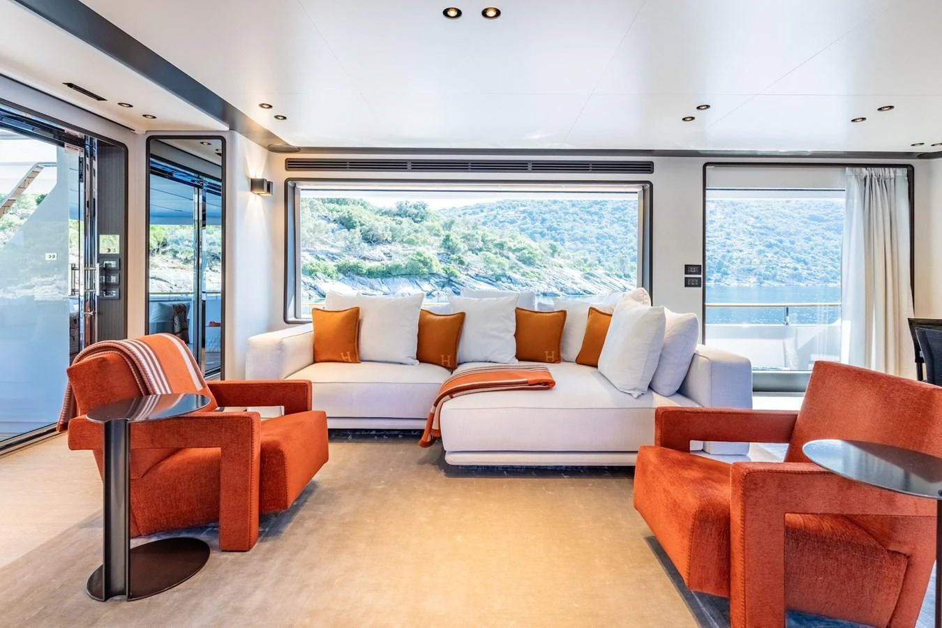 The salon features a spacious and stylish seating area with large windows offering stunning views. aboard AT ONE Yacht for Sale