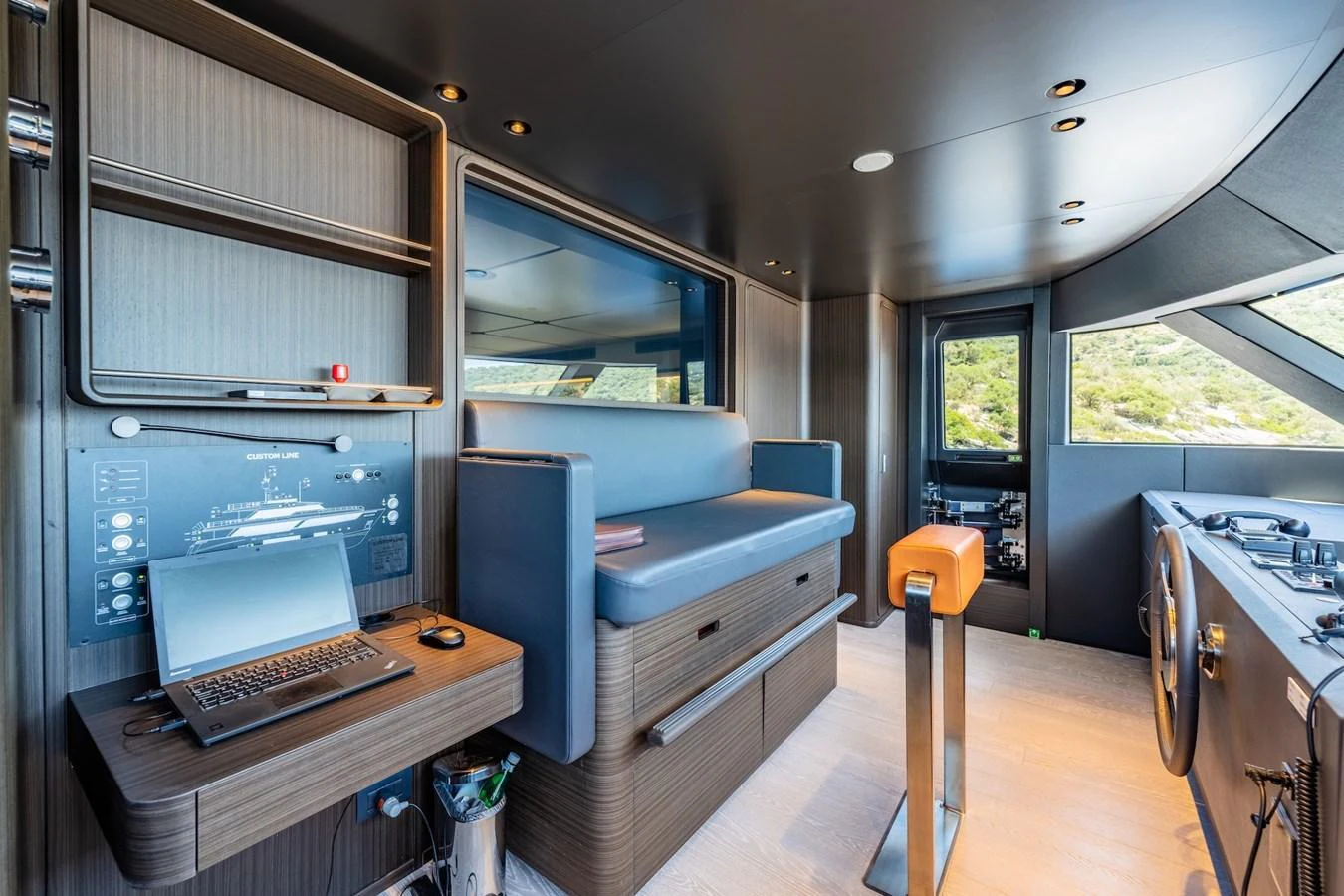 The helm station features modern controls, a comfortable seating area, and expansive windows for optimal visibility. aboard AT ONE Yacht for Sale