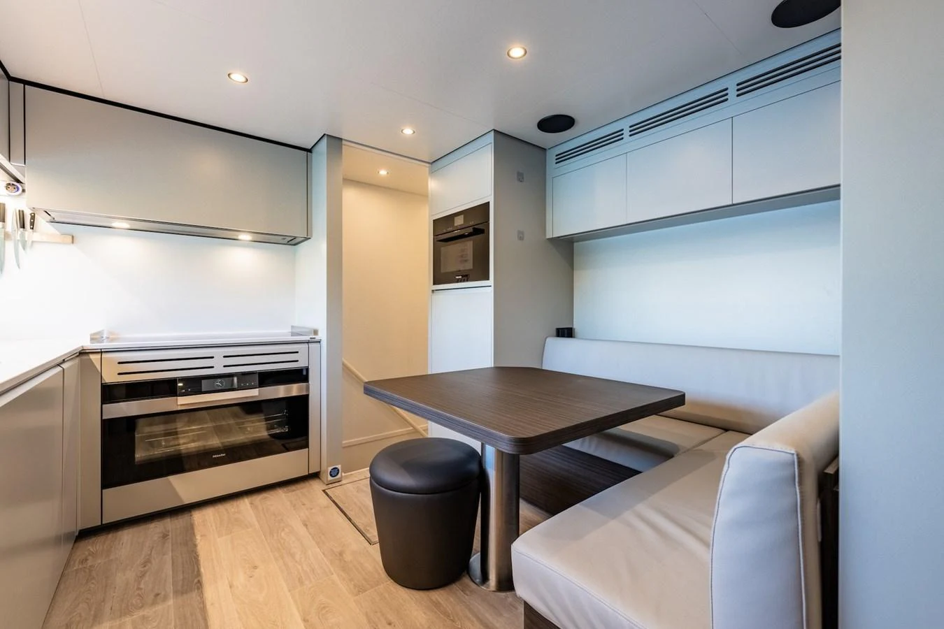 The yacht's galley features modern appliances and a cozy dining area with a sleek, contemporary design. aboard AT ONE Yacht for Sale