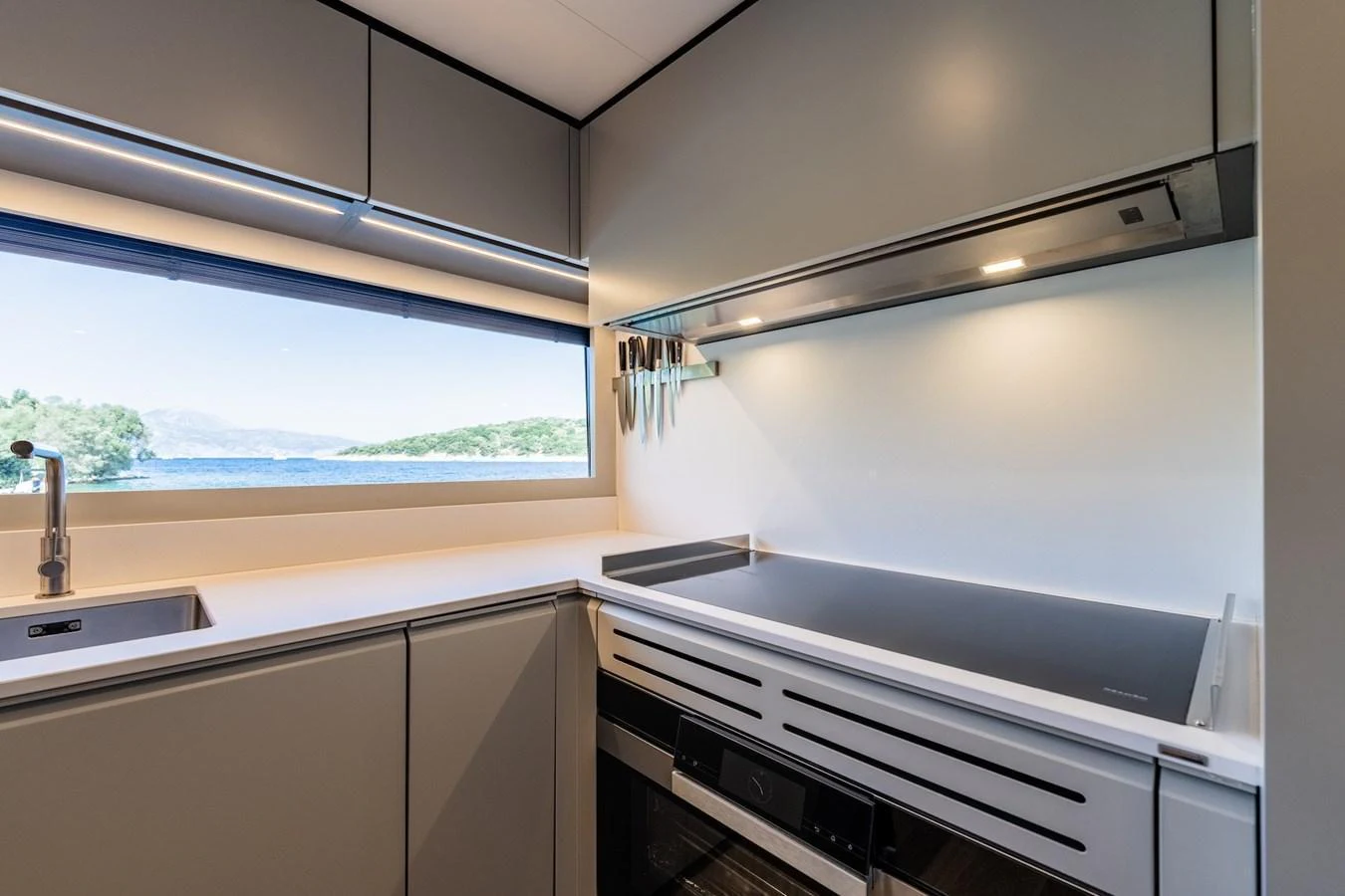 The yacht's galley features modern appliances and a scenic window view. aboard AT ONE Yacht for Sale