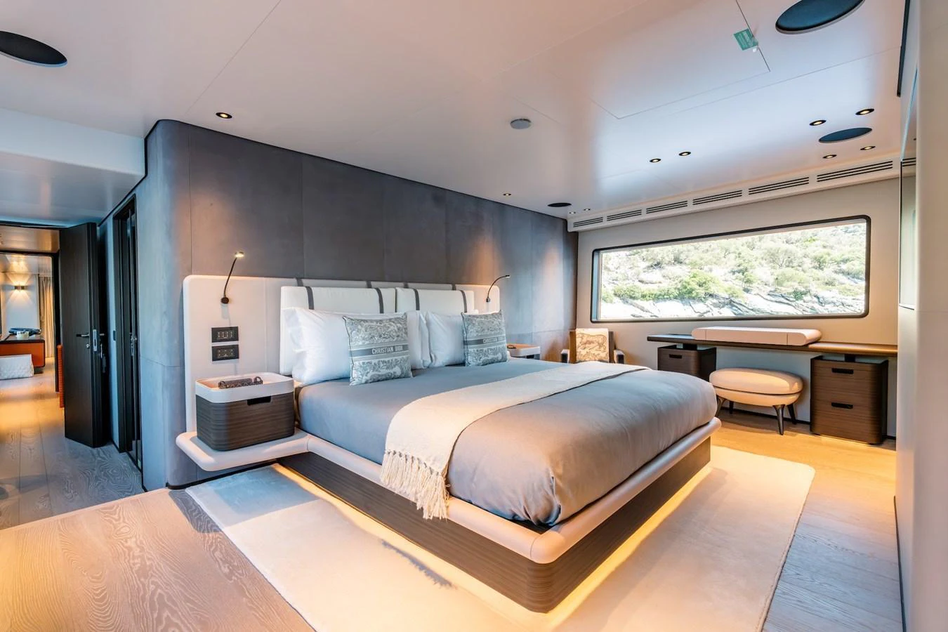 The master stateroom features a luxurious bed with modern decor and a large window offering scenic views. aboard AT ONE Yacht for Sale