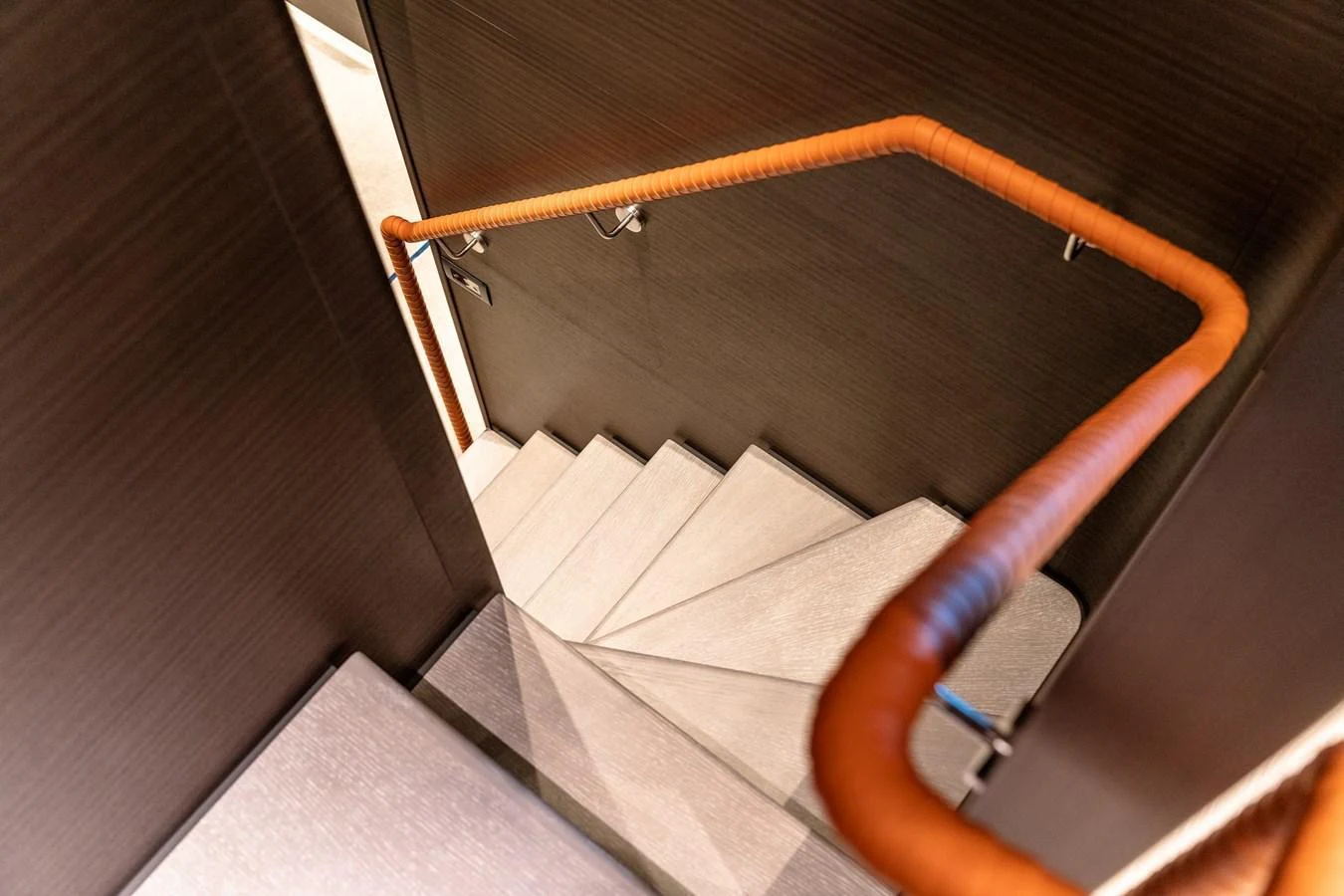 A sleek and modern staircase with a leather-wrapped handrail and minimalist design. aboard AT ONE Yacht for Sale