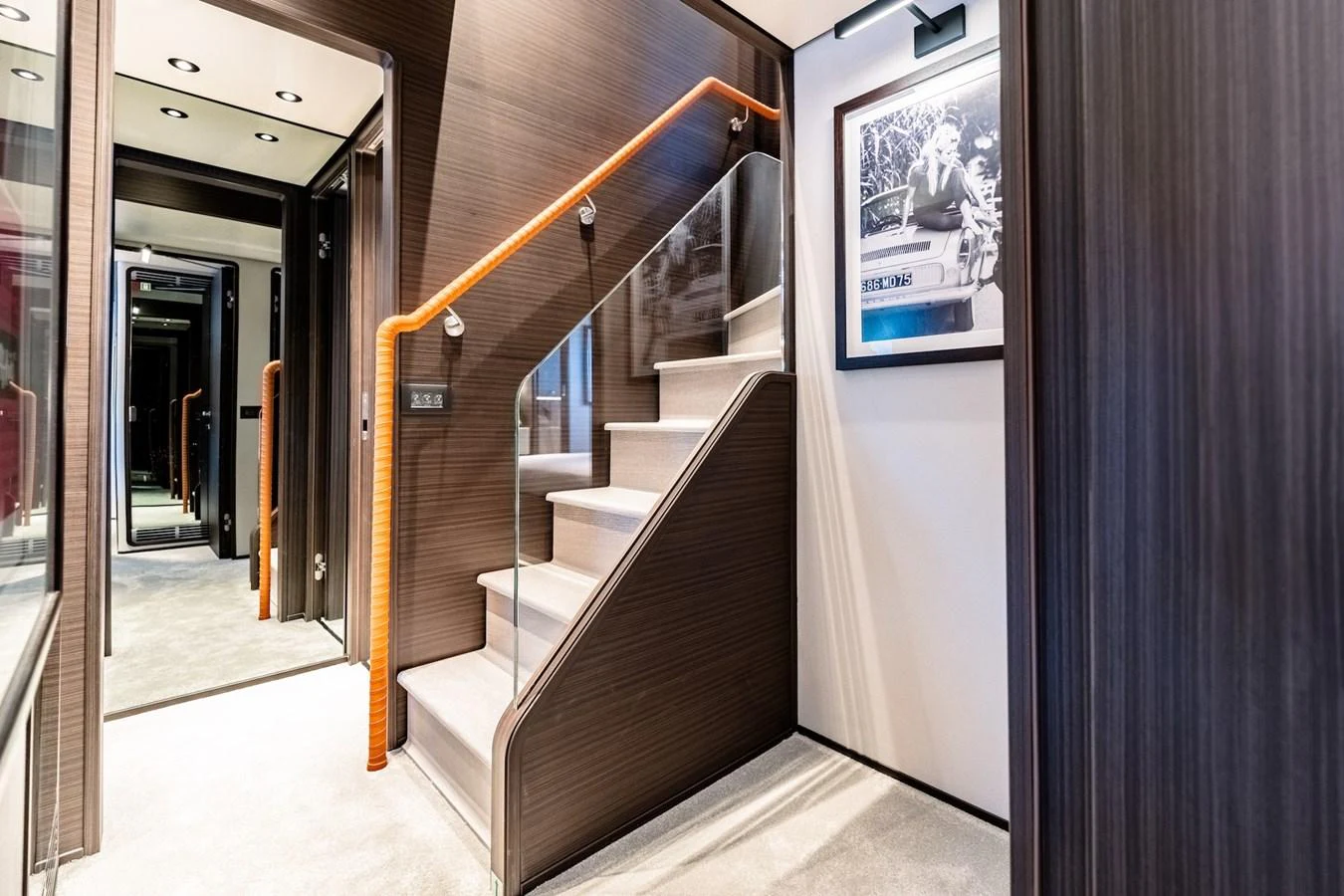A modern and elegant staircase with wooden paneling and a sleek handrail. aboard AT ONE Yacht for Sale