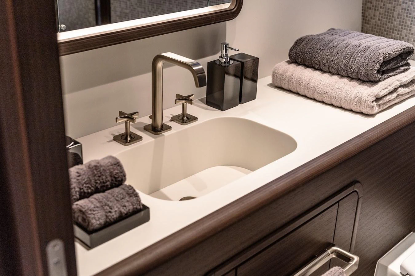 The yacht's bathroom features a sleek, modern sink area with luxurious towels and elegant fixtures. aboard AT ONE Yacht for Sale