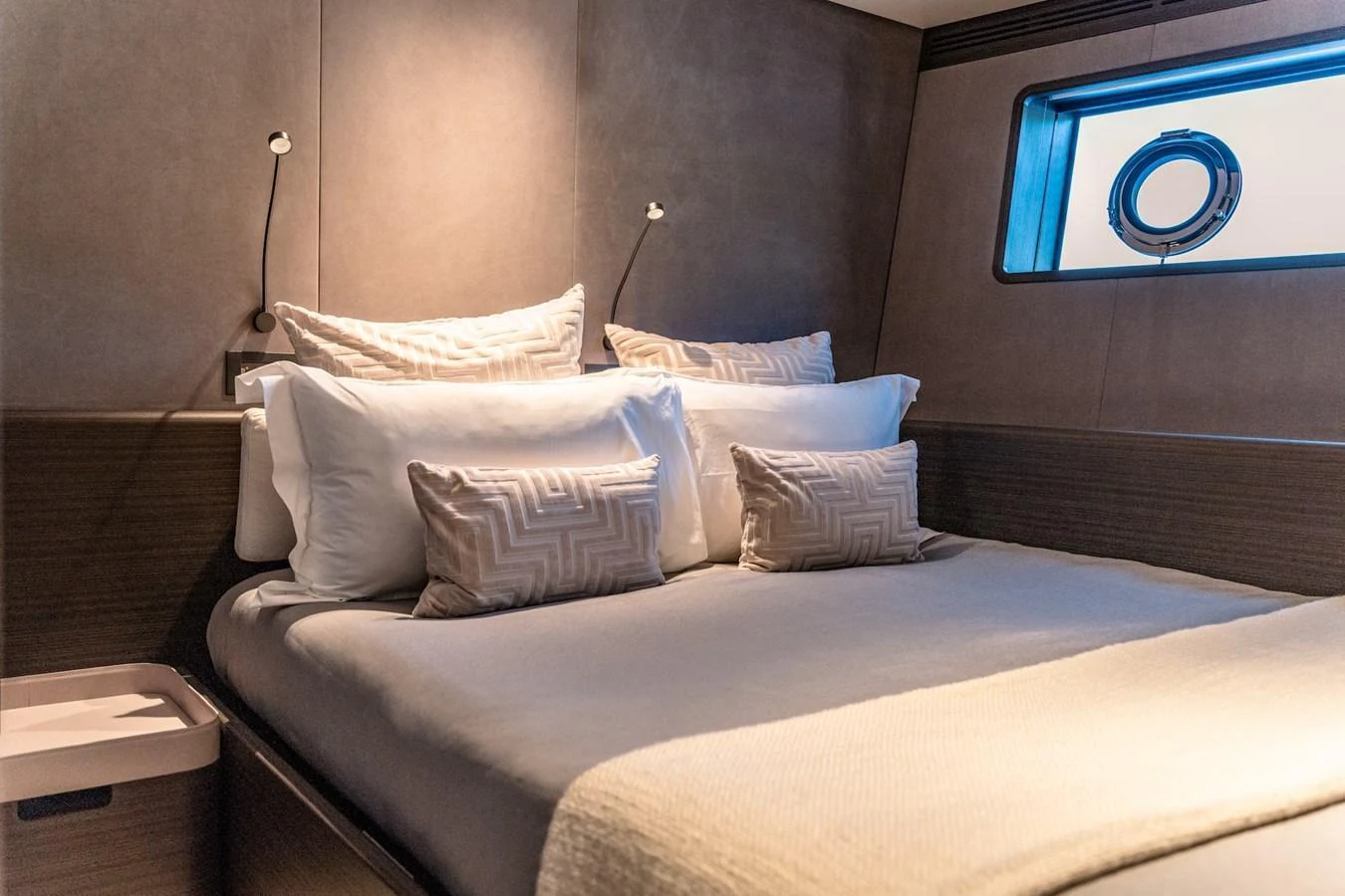 The stateroom features a cozy bed with plush pillows and a modern, elegant design. aboard AT ONE Yacht for Sale