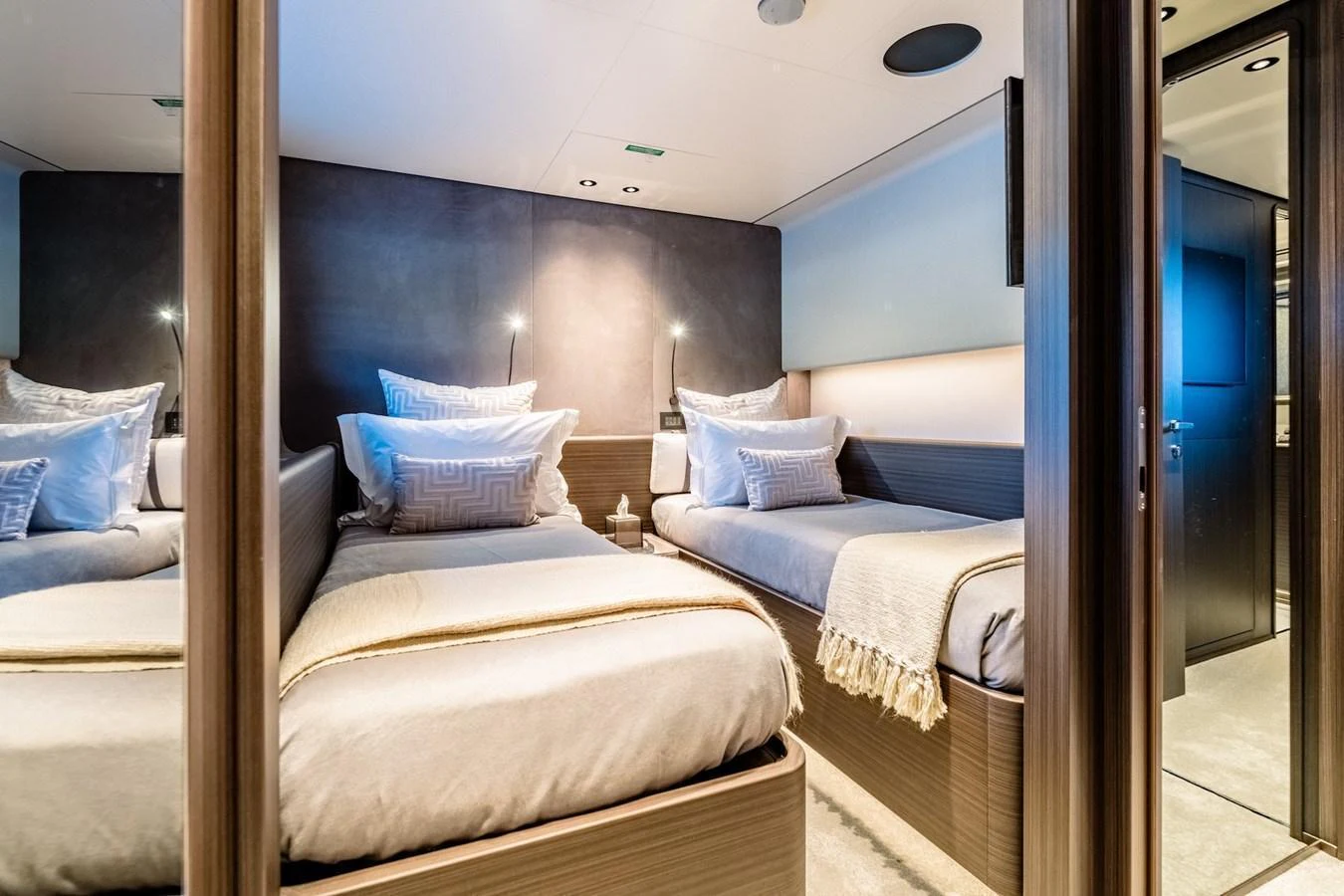 The guest stateroom features twin beds with luxurious bedding and modern lighting. aboard AT ONE Yacht for Sale