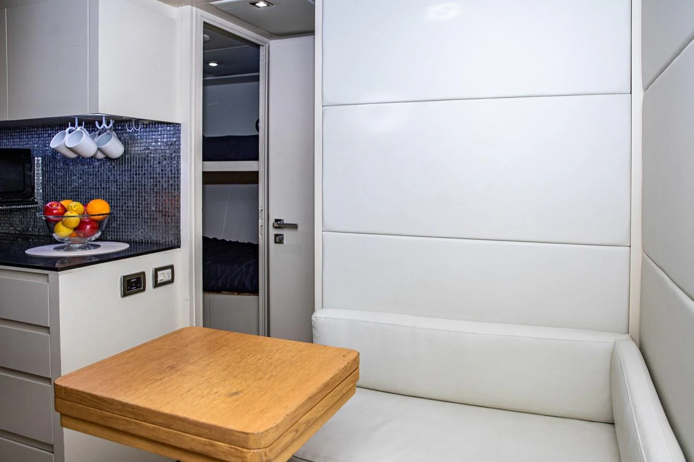 The yacht's dining area features a cozy seating arrangement with a wooden table and modern decor. aboard DOROTHY ANN Yacht for Sale