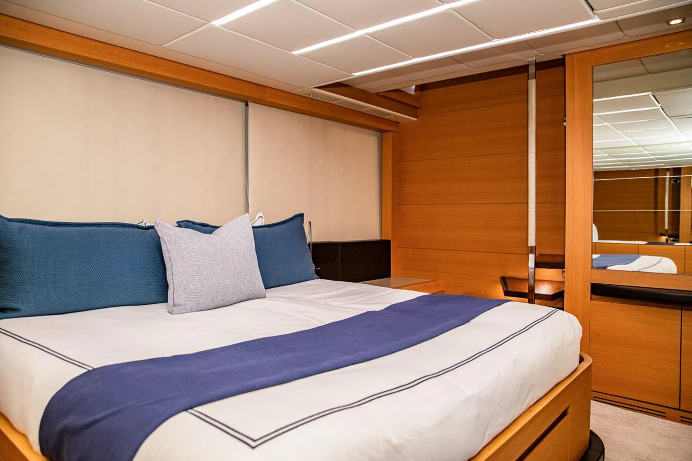 A luxurious stateroom featuring a comfortable bed with elegant linens and modern wooden finishes. aboard DOROTHY ANN Yacht for Sale