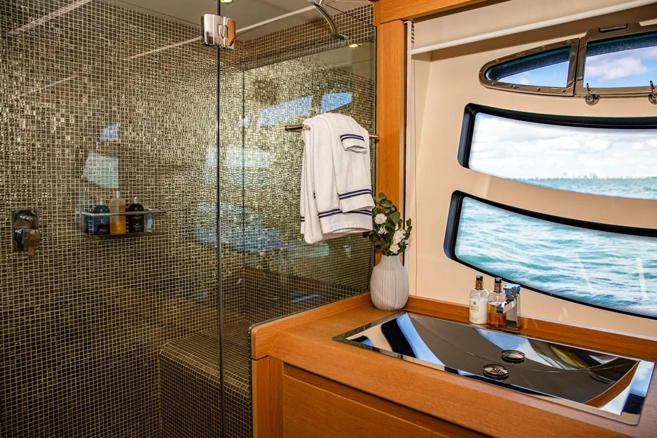 The yacht's bathroom features a sleek design with a glass shower and a view of the sea through the window. aboard DOROTHY ANN Yacht for Sale
