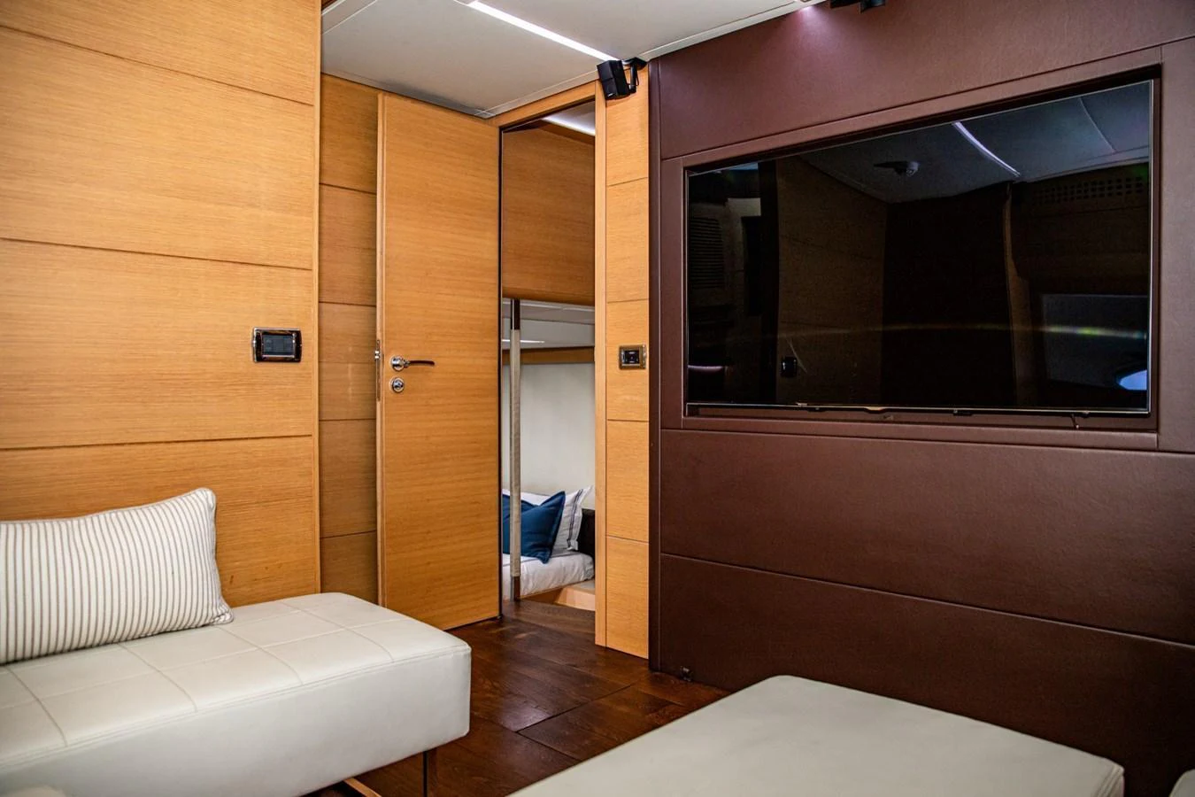 The stateroom features modern wood paneling and a large flat-screen TV for a luxurious onboard experience. aboard DOROTHY ANN Yacht for Sale