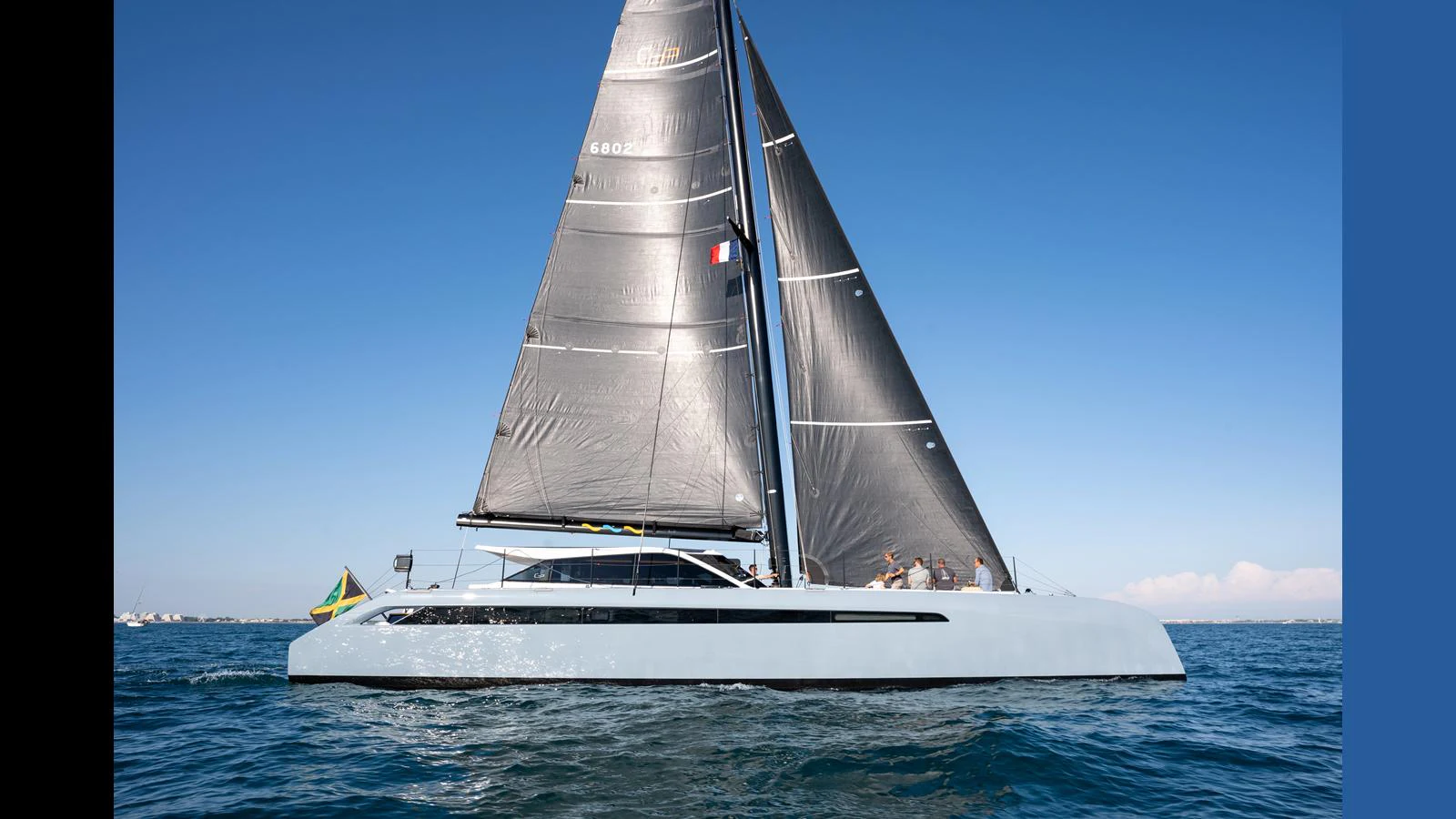 A sleek, modern sailing yacht glides gracefully on the open water under clear blue skies. aboard GUNBOAT 80 Yacht for Sale