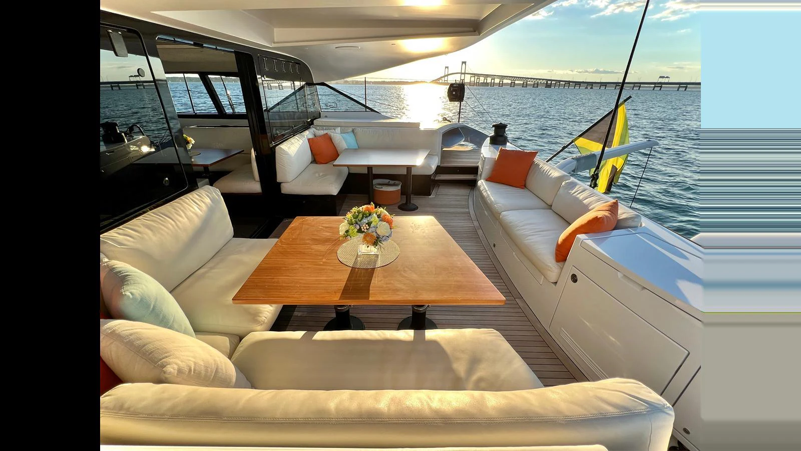 The aft deck offers a luxurious seating area with a stunning view of the sunset over the water. aboard GUNBOAT 80 Yacht for Sale