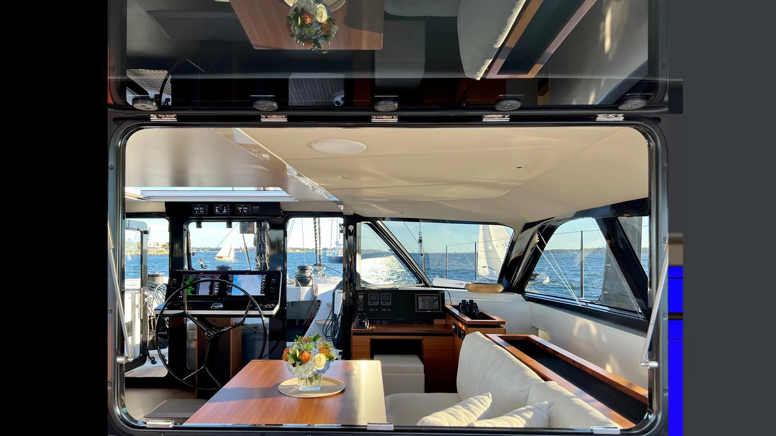 The yacht's salon features a comfortable seating area with a view of the helm and large windows offering a panoramic view of the sea. aboard GUNBOAT 80 Yacht for Sale