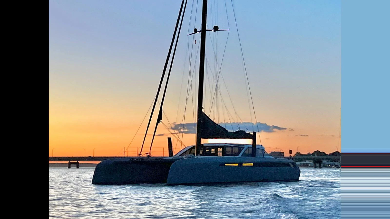 A sleek catamaran yacht is anchored at sunset, showcasing its modern design and spacious deck. aboard GUNBOAT 80 Yacht for Sale