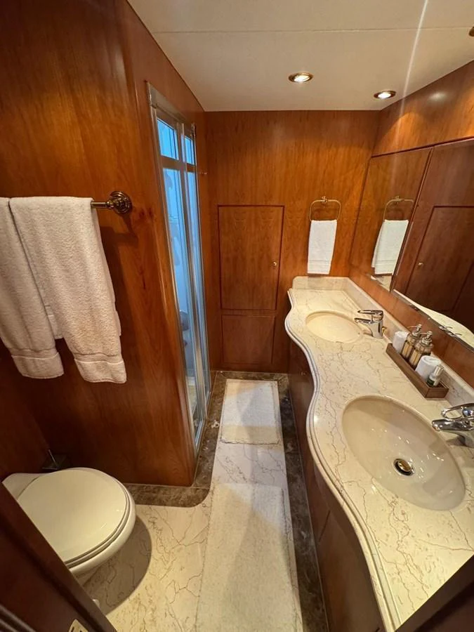 The yacht's bathroom features elegant wood paneling and a marble countertop. aboard 68' HARGRAVE OPEN BRIDGE Yacht for Sale