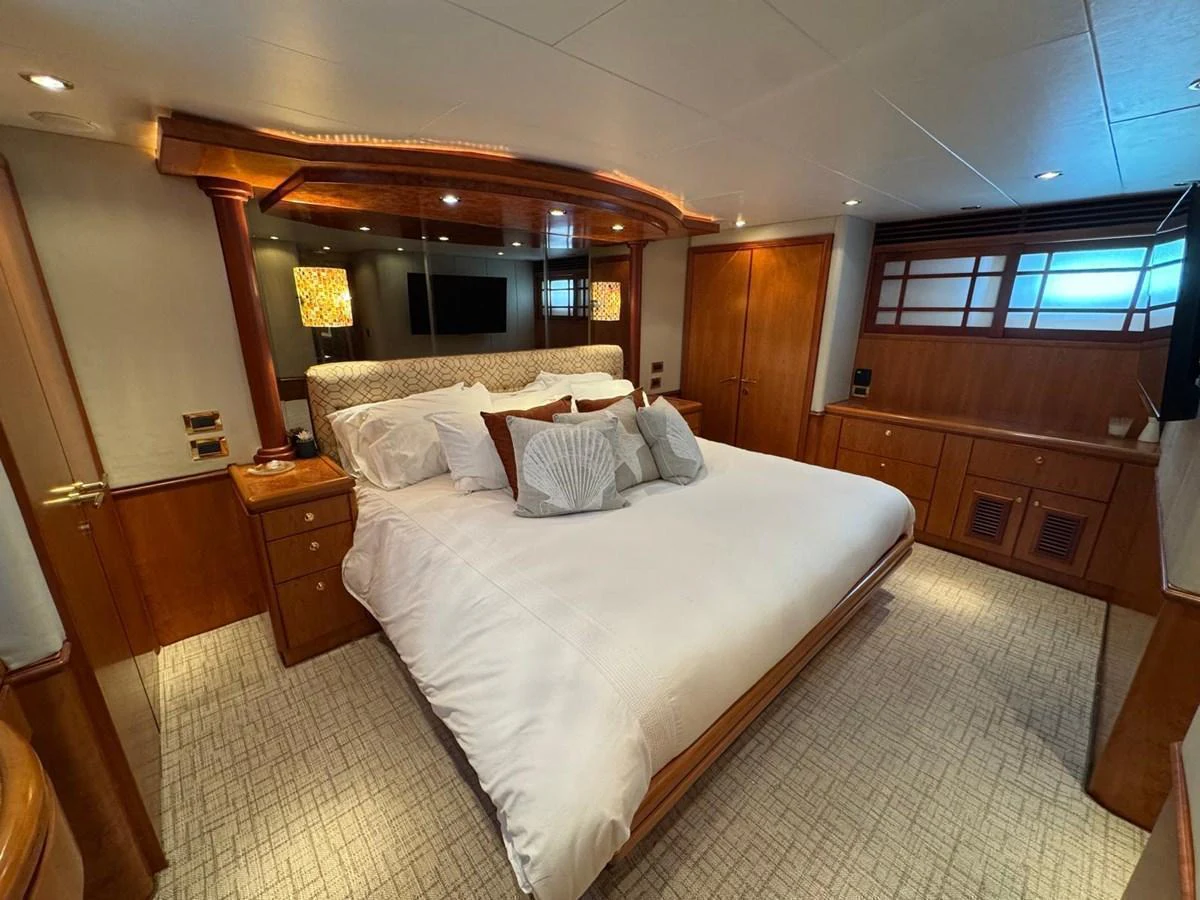 The master stateroom features a luxurious bed with elegant wood finishes and ambient lighting. aboard 68' HARGRAVE OPEN BRIDGE Yacht for Sale