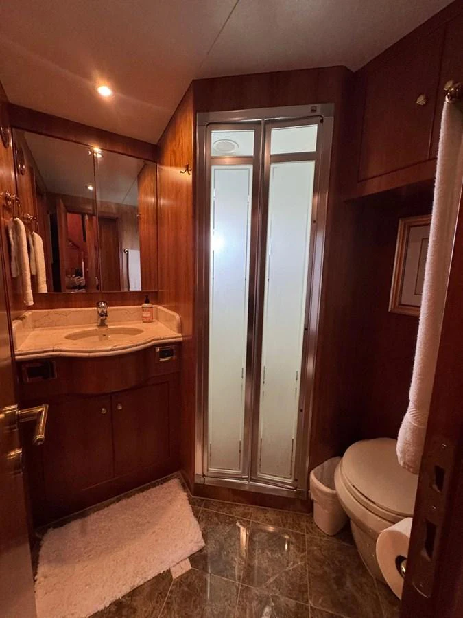 A luxurious yacht bathroom featuring a sleek shower, elegant vanity, and rich wood finishes. aboard 68' HARGRAVE OPEN BRIDGE Yacht for Sale