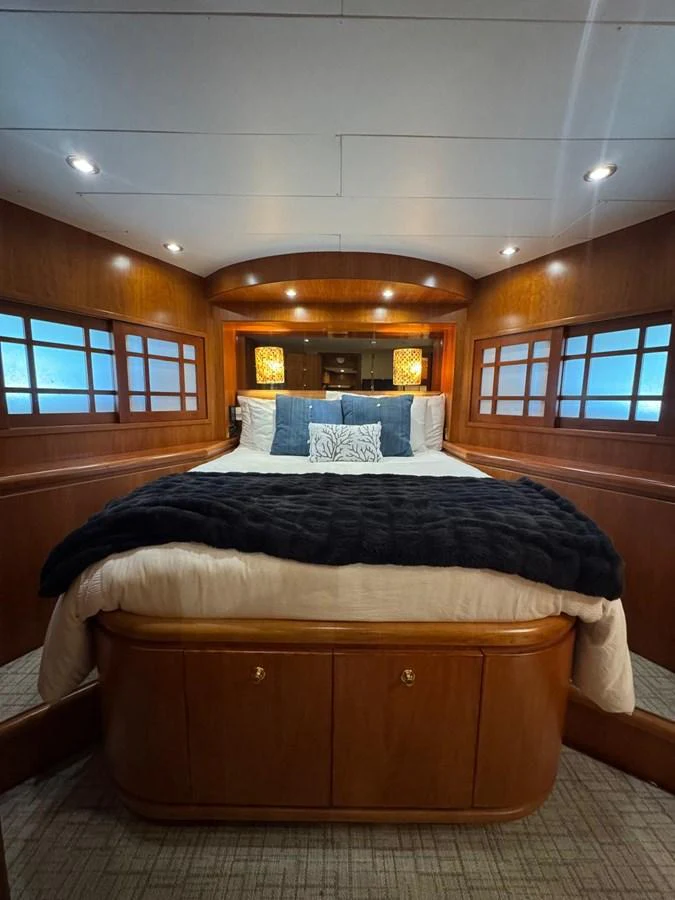 A cozy stateroom featuring a plush bed with elegant lighting and wooden accents. aboard 68' HARGRAVE OPEN BRIDGE Yacht for Sale