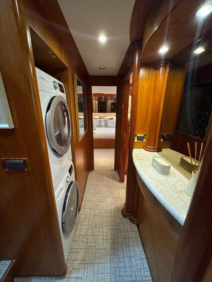 A cozy interior hallway featuring a laundry area and a glimpse into a bedroom. aboard 68' HARGRAVE OPEN BRIDGE Yacht for Sale