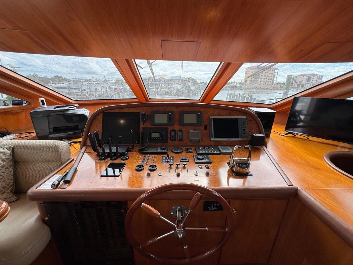 The helm station features a polished wooden console with an array of navigational instruments and large windows offering a panoramic view. aboard 68' HARGRAVE OPEN BRIDGE Yacht for Sale