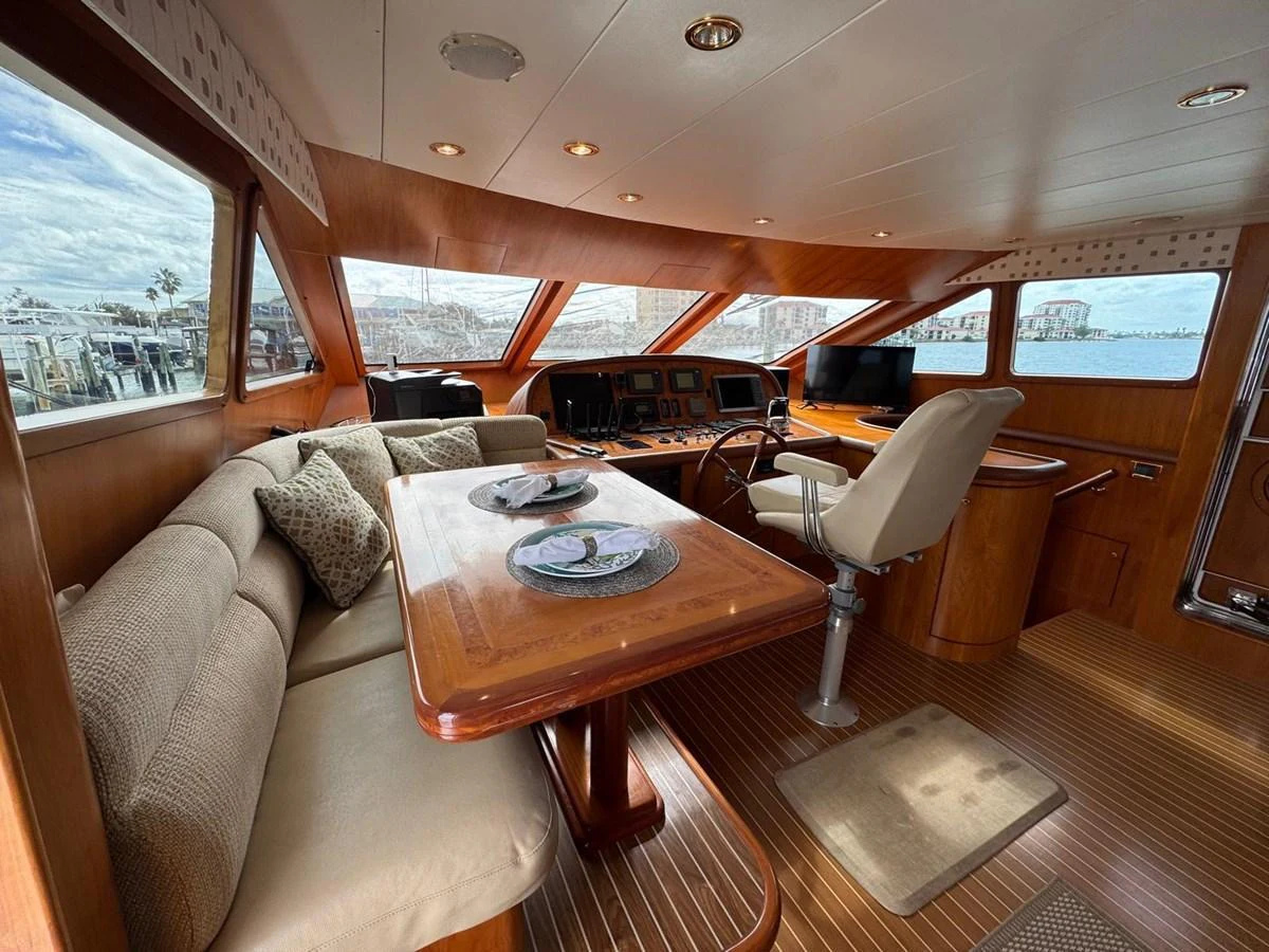 The helm area features a comfortable seating arrangement with a dining table and a well-equipped control station. aboard 68' HARGRAVE OPEN BRIDGE Yacht for Sale