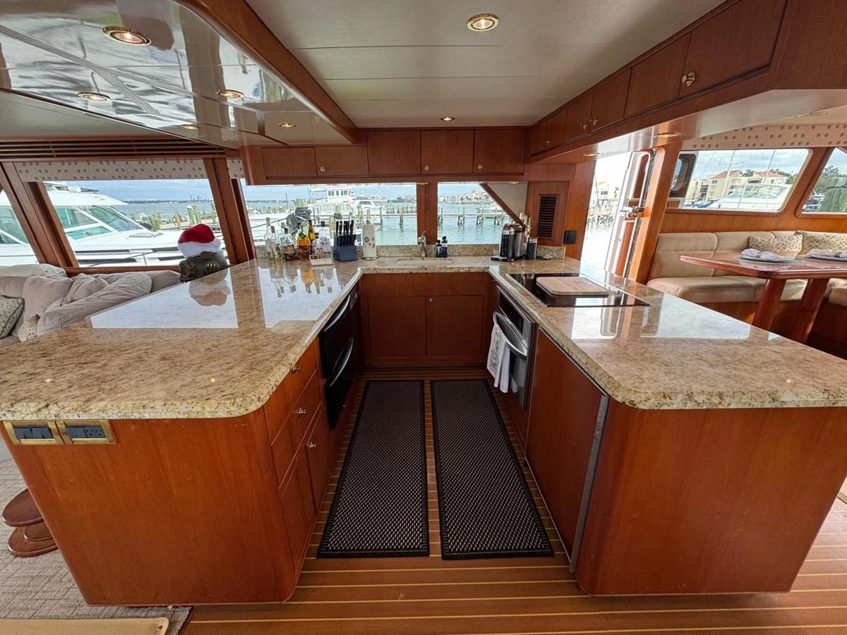 The yacht's galley features elegant wood cabinetry and granite countertops, offering a spacious and well-equipped area for meal preparation. aboard 68' HARGRAVE OPEN BRIDGE Yacht for Sale