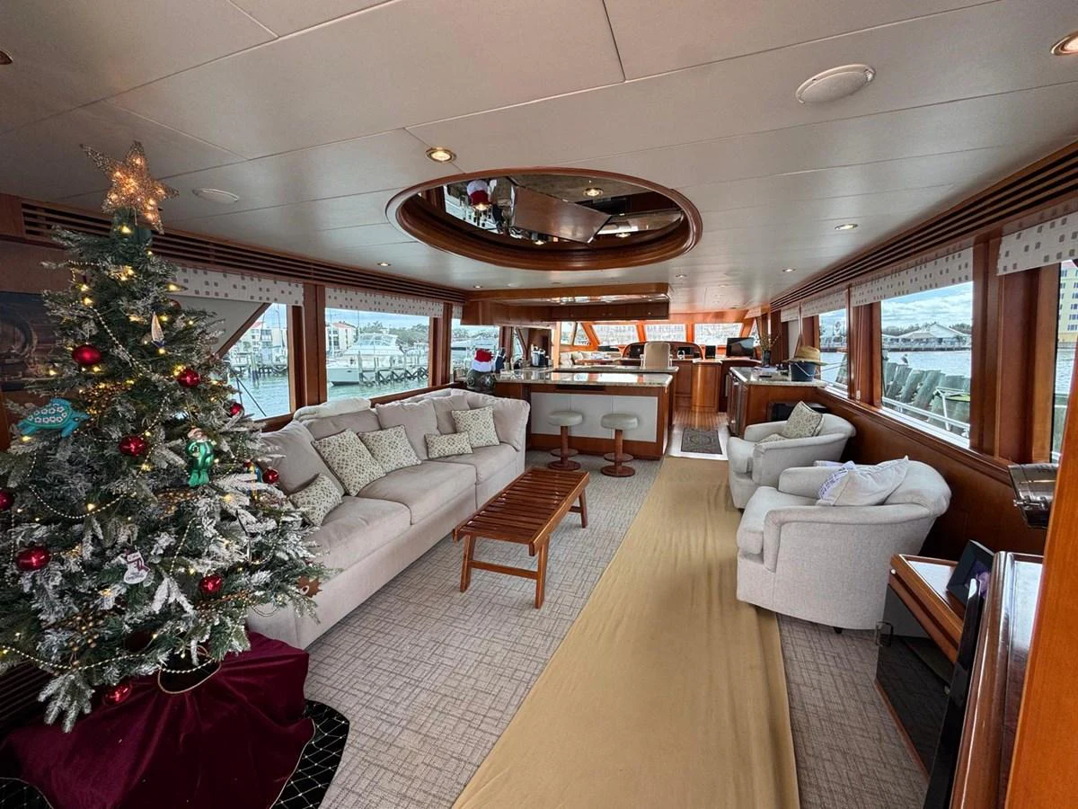 The salon features a cozy seating area with a festive Christmas tree, offering a warm and inviting atmosphere. aboard 68' HARGRAVE OPEN BRIDGE Yacht for Sale