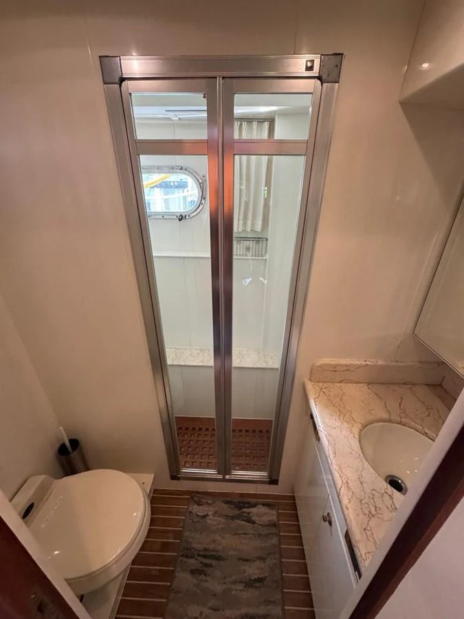 The yacht's bathroom features a sleek shower with glass doors and a modern vanity with a marble countertop. aboard 68' HARGRAVE OPEN BRIDGE Yacht for Sale