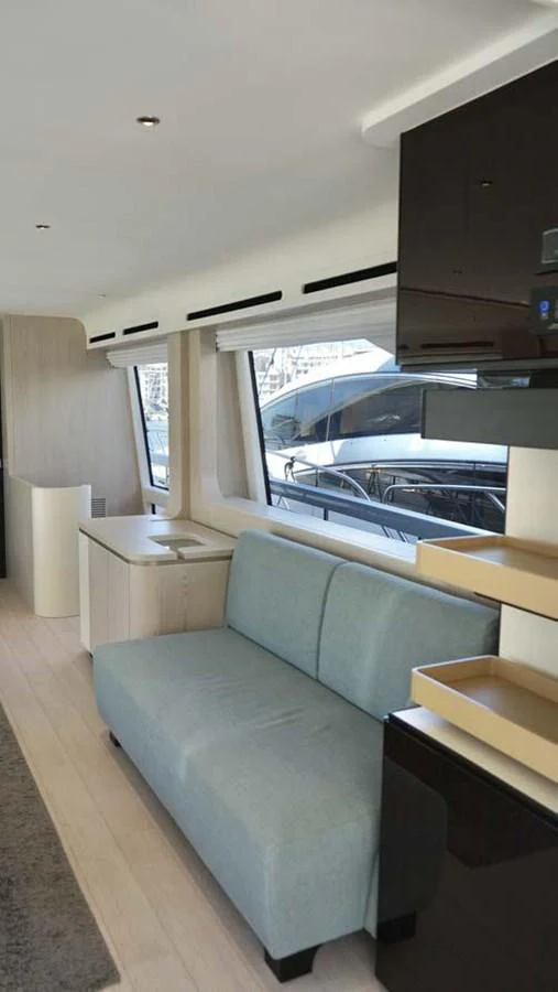 The yacht's interior features a comfortable seating area with large windows providing ample natural light. aboard KOKO Yacht for Sale