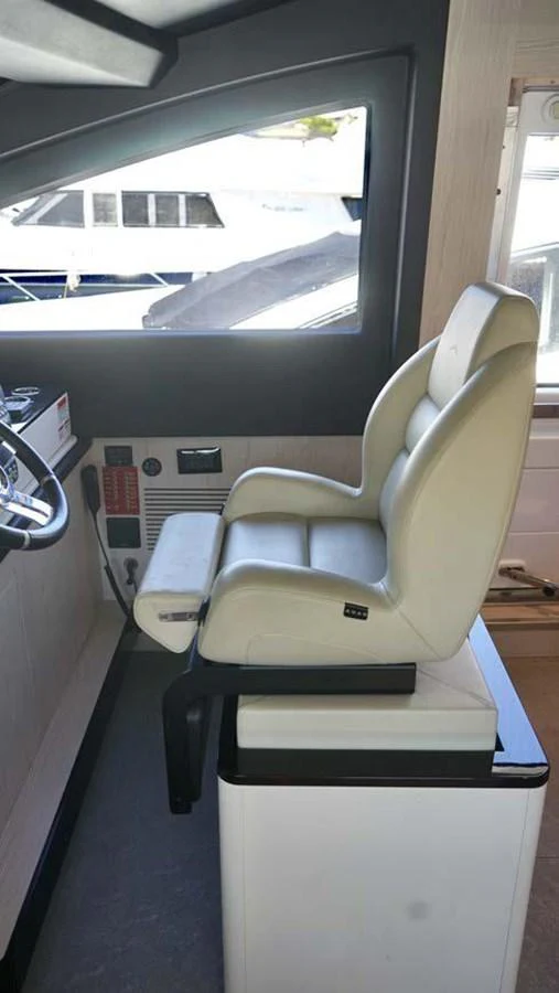The helm station features a comfortable captain's chair with a view of the marina. aboard KOKO Yacht for Sale