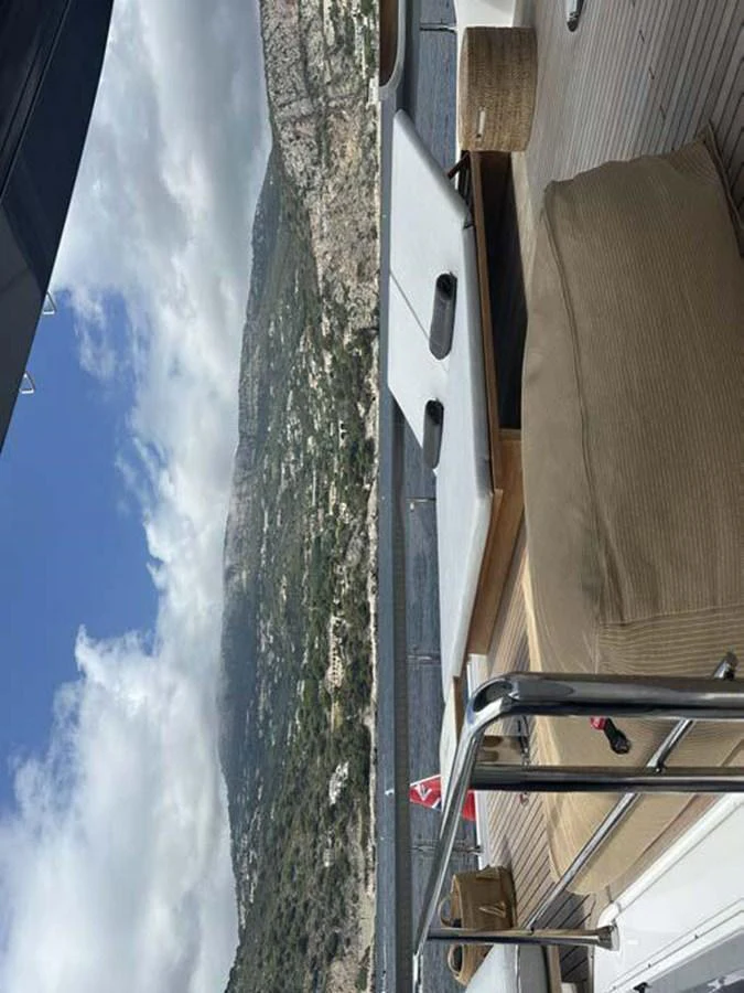 A serene view from the yacht's deck, showcasing comfortable seating and a scenic backdrop. aboard KOKO Yacht for Sale