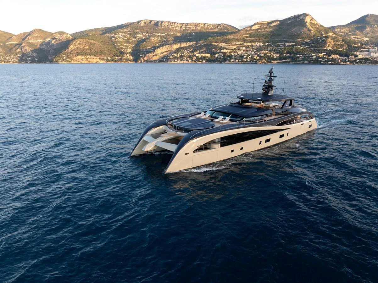 A sleek, modern yacht glides through calm waters with a scenic coastal backdrop. aboard SEAWOLF X Yacht for Sale