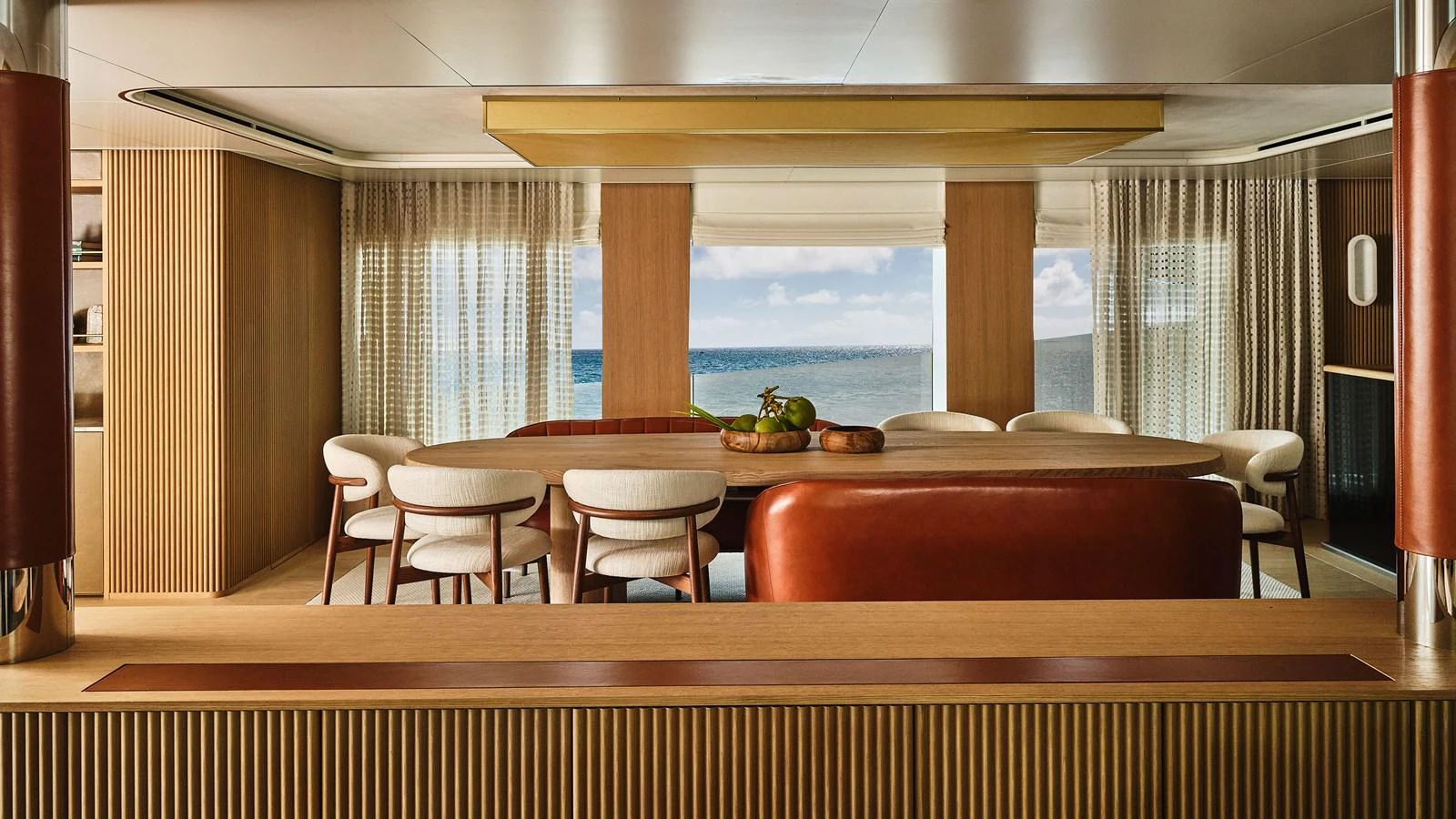 The yacht's interior dining area features elegant seating with a view of the ocean through large windows. aboard SEAWOLF X Yacht for Sale