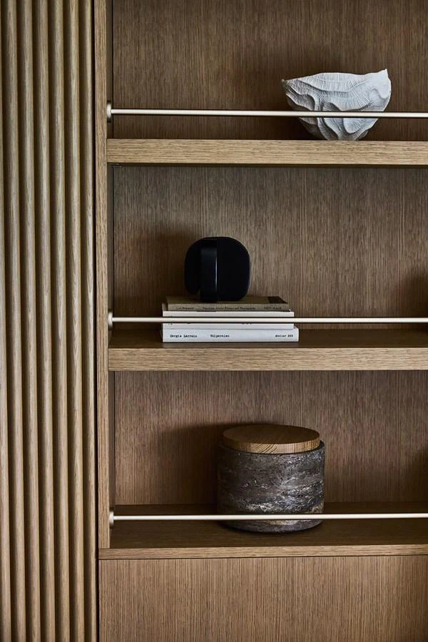 A close-up of a stylish wooden shelving unit with decorative items. aboard SEAWOLF X Yacht for Sale