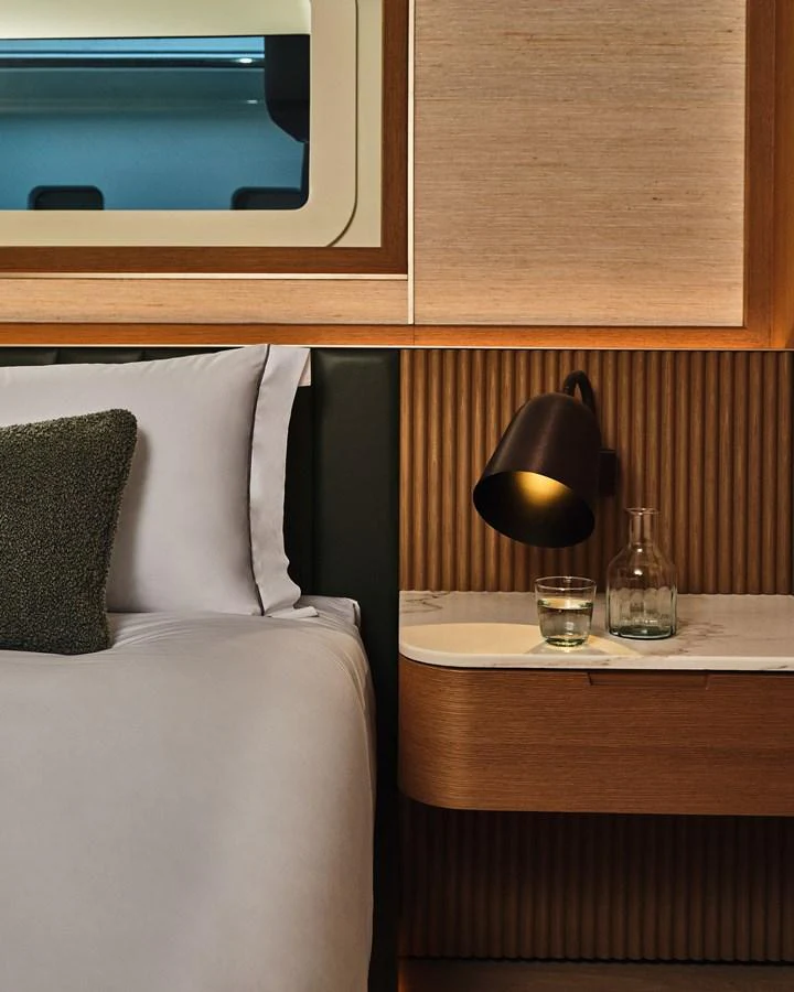 A cozy stateroom with a modern design, featuring a bedside table and a stylish lamp. aboard SEAWOLF X Yacht for Sale