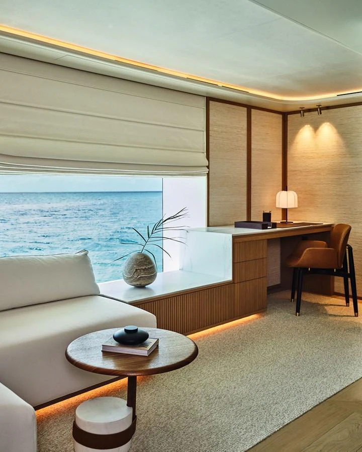 A serene lounge area with a view of the sea, featuring a cozy seating arrangement and a stylish desk. aboard SEAWOLF X Yacht for Sale