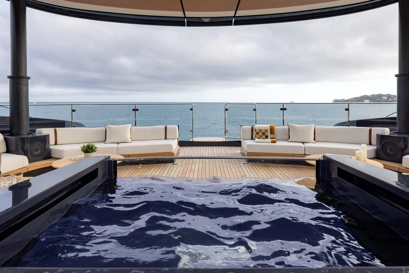 The aft deck features a luxurious jacuzzi surrounded by comfortable seating with a stunning ocean view. aboard SEAWOLF X Yacht for Sale