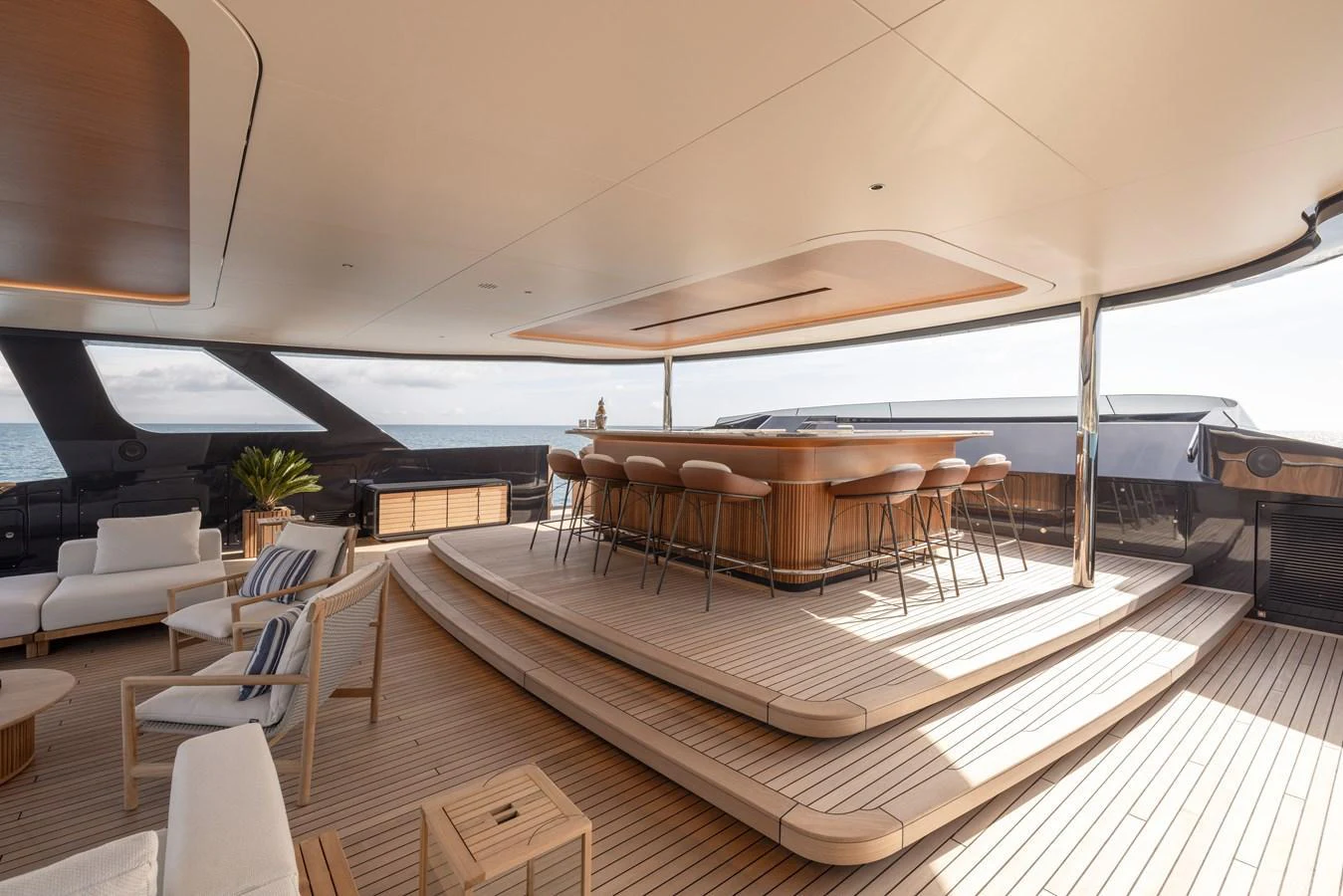 The aft deck features a stylish bar area with ample seating and elegant wooden flooring. aboard SEAWOLF X Yacht for Sale