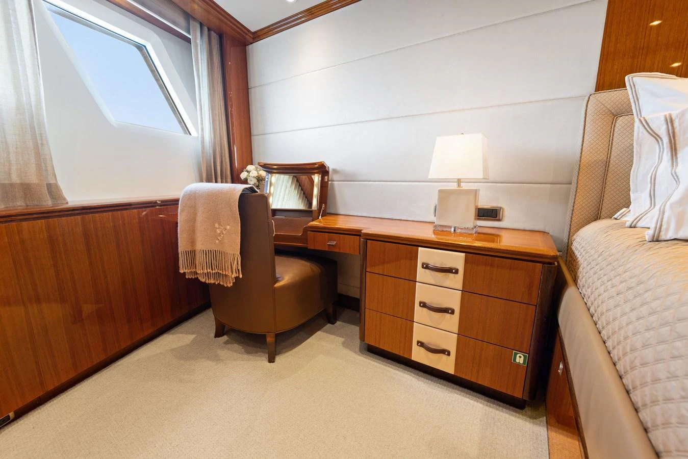 a bedroom with a bed and a chair aboard STAMPEDE Yacht for Sale