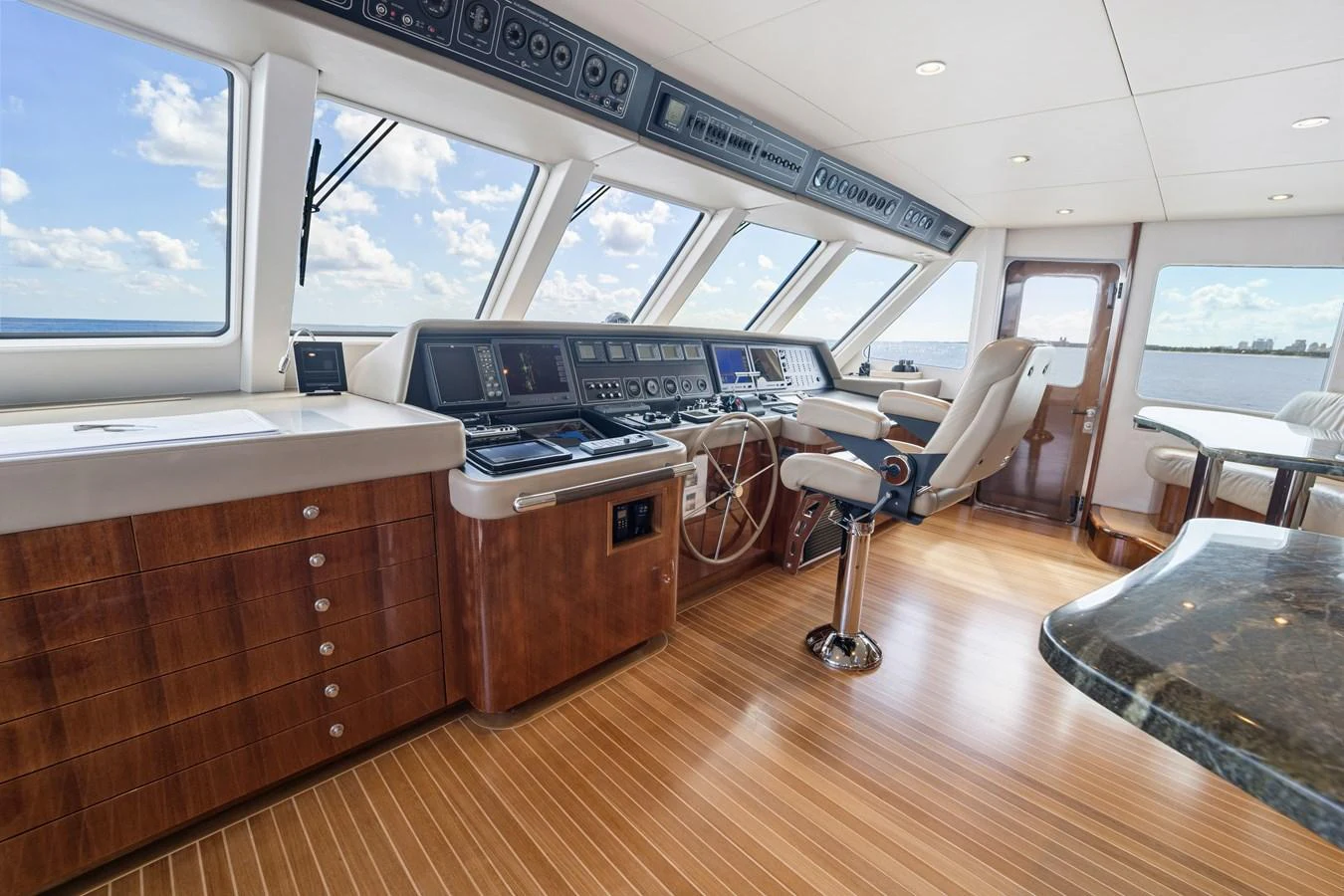 a room with a large window and a large table with chairs and a large window aboard STAMPEDE Yacht for Sale