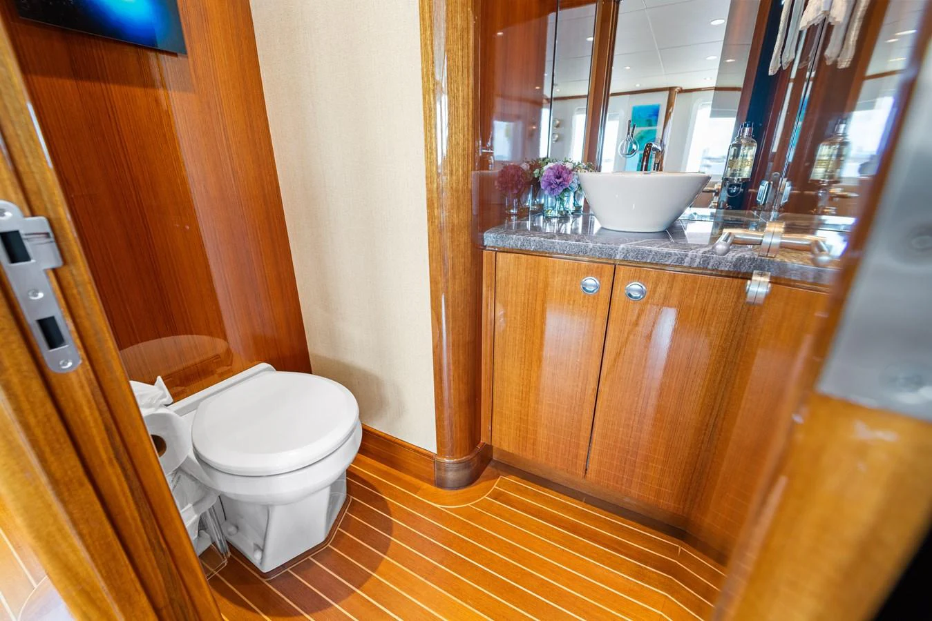 a bathroom with a sink toilet and a mirror aboard STAMPEDE Yacht for Sale