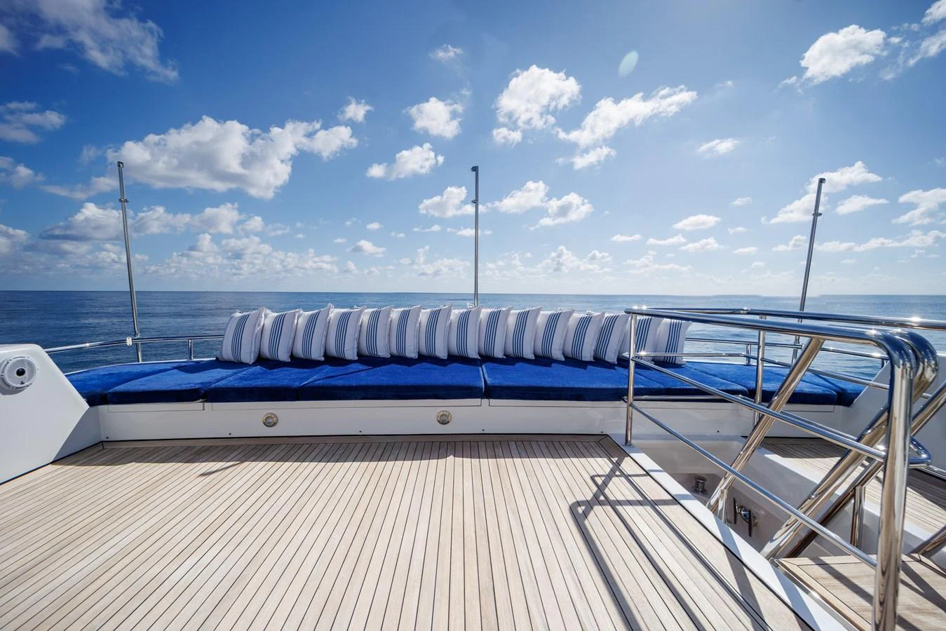 a deck with a railing and a wind turbine in the background aboard STAMPEDE Yacht for Sale