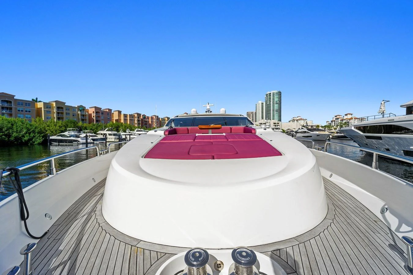 The yacht's foredeck features a spacious sunbathing area with vibrant red cushions, perfect for relaxation. aboard GBXSK84PRD13 Yacht for Sale