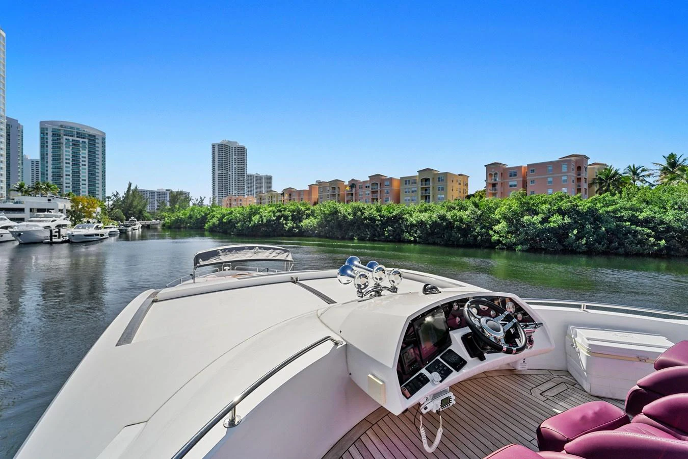 The yacht's helm offers a sophisticated control area with a scenic view of the waterway and cityscape. aboard GBXSK84PRD13 Yacht for Sale