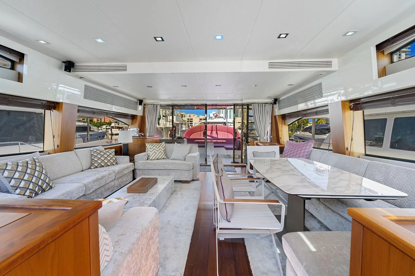 The spacious salon features elegant seating and a dining area with large windows for natural light. aboard GBXSK84PRD13 Yacht for Sale