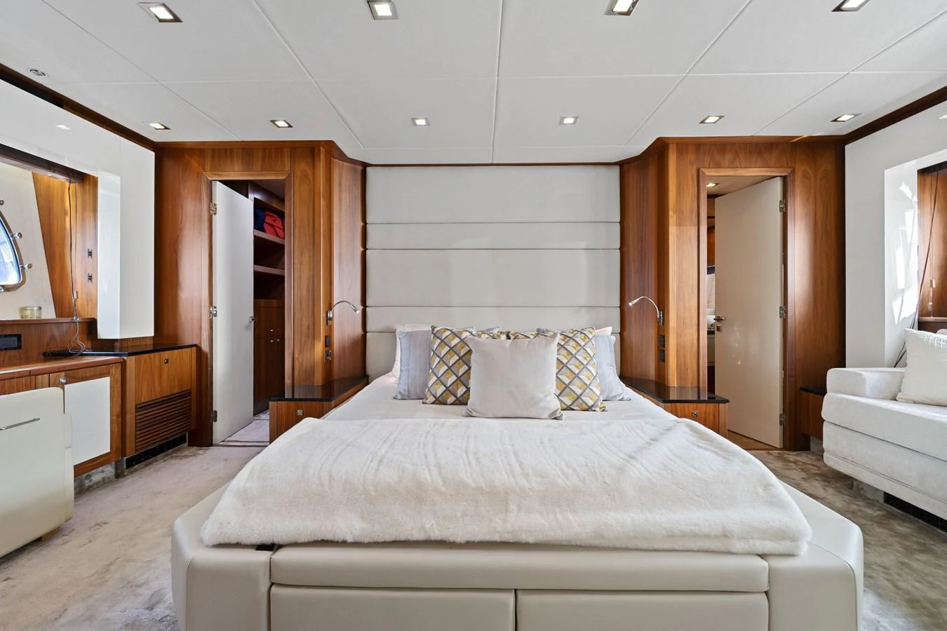 The master stateroom features a luxurious bed with elegant wood paneling and ample natural light. aboard GBXSK84PRD13 Yacht for Sale