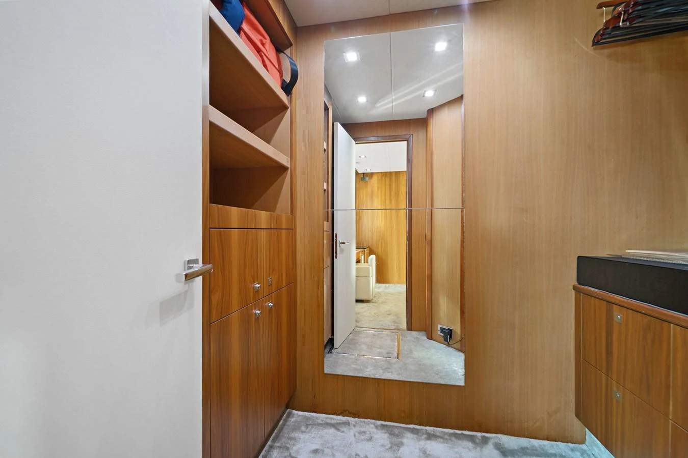 A modern yacht interior featuring wooden cabinetry and a large mirror reflecting the space. aboard GBXSK84PRD13 Yacht for Sale