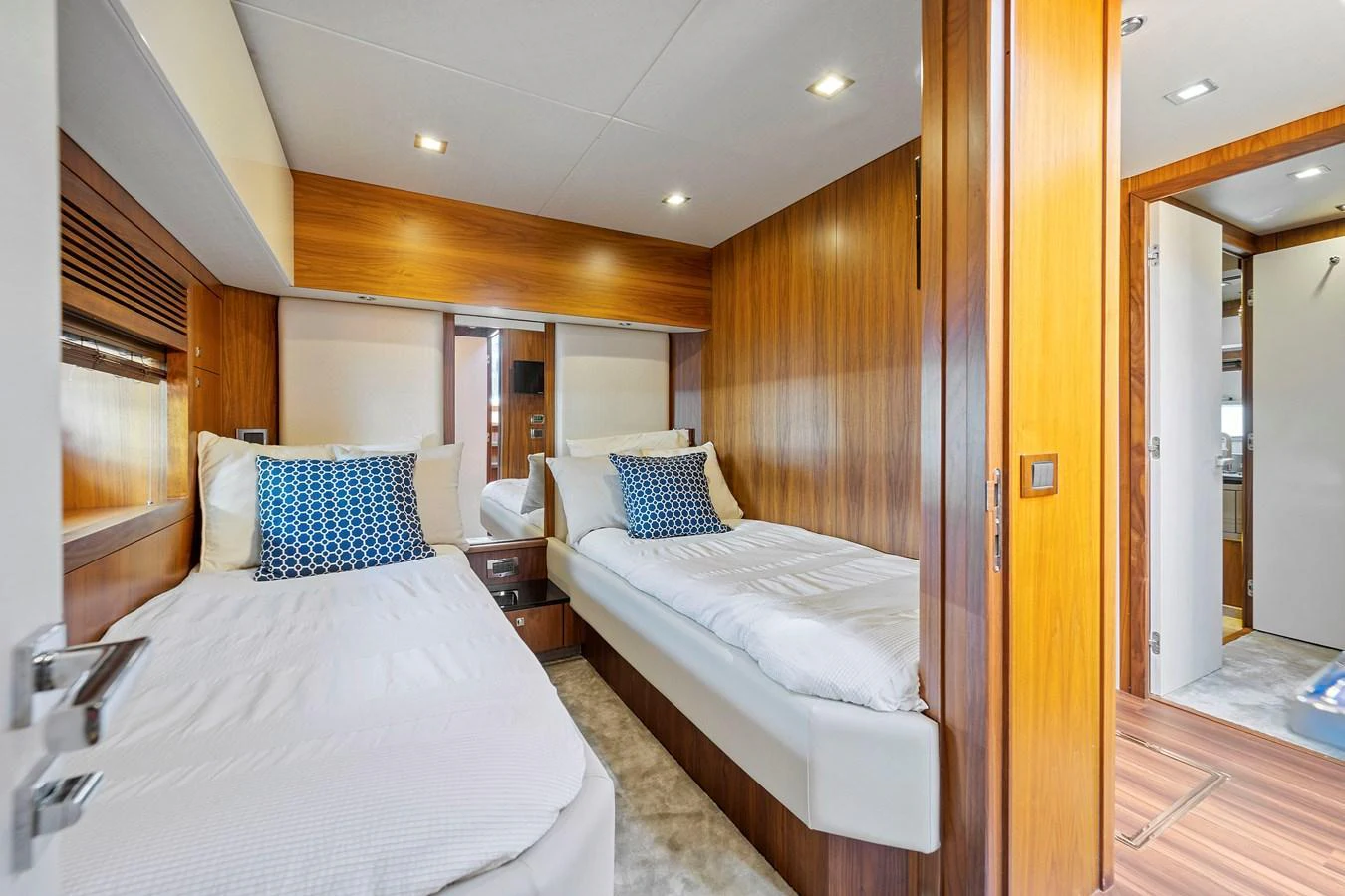 The twin stateroom features two single beds with plush bedding and elegant wooden finishes. aboard GBXSK84PRD13 Yacht for Sale