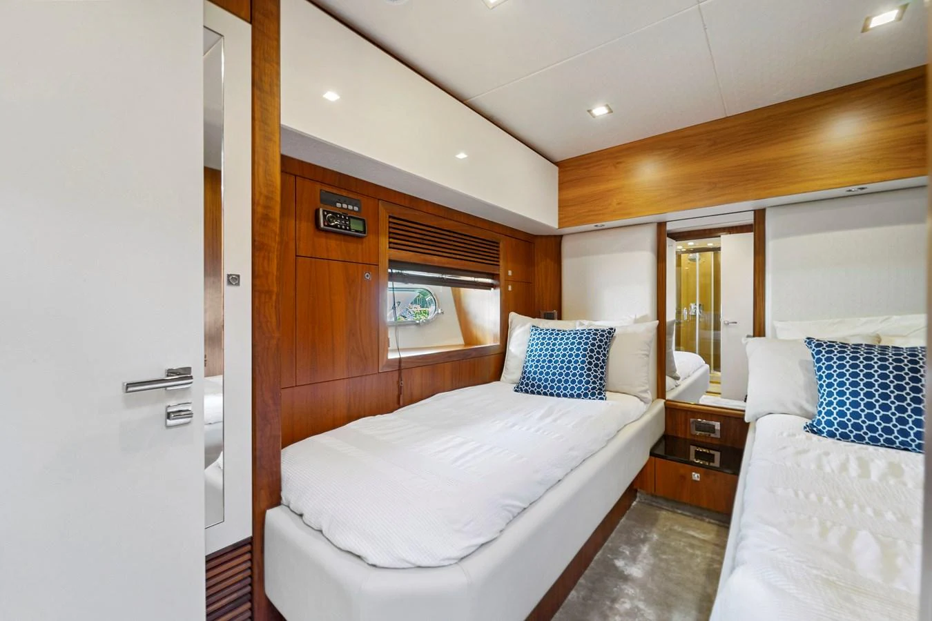 The guest stateroom features twin beds with plush white linens and stylish blue accent pillows. aboard GBXSK84PRD13 Yacht for Sale